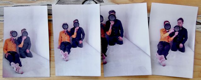 The two protagonists, sitting upright, hiding their faces behind speaker conusses, partly successfully.