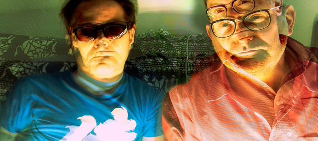 Double portrait of the protagonists on a sofa, bright light from the bottom, layered from several photos.